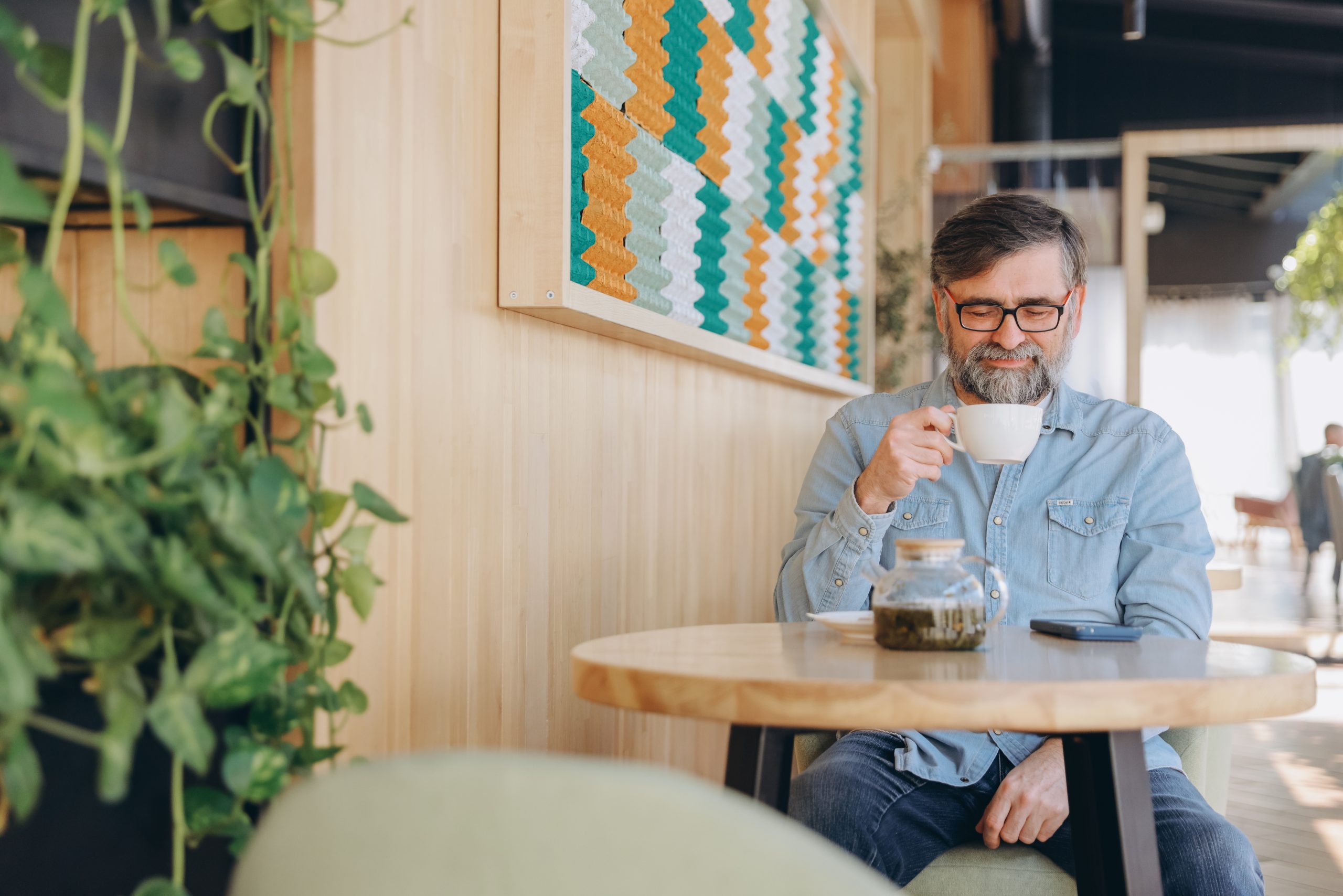 senior man drinking tea in a modern cafe 2025 09 10 05 03 48 utc scaled